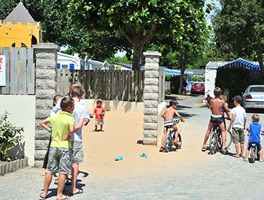 Kinder auf Fahrrädern spielen im Kinderclub auf dem Campingplatz in Saint-Hilaire de Riez
