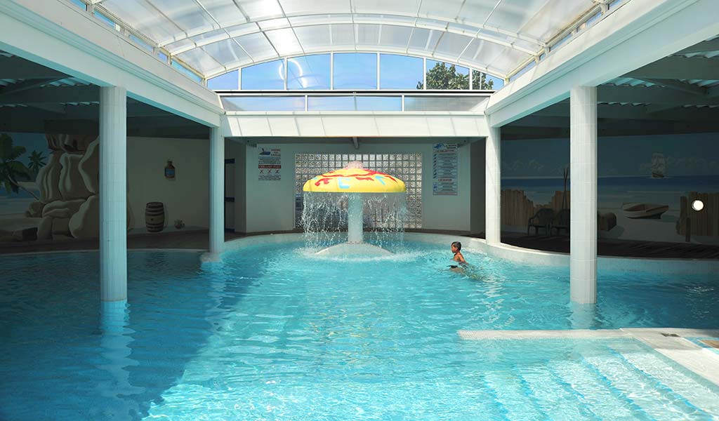 Indoor pool and fountain at Le Bois Tordu campsite in Vendée