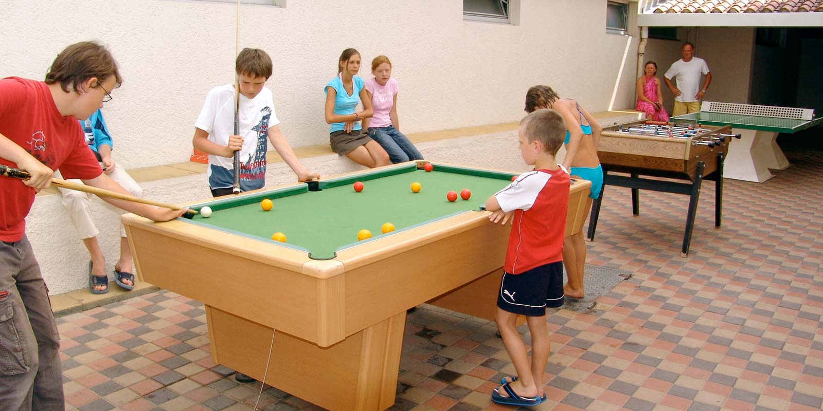 Kinderen spelen biljart in de speelkamer van de camping in Saint-Hilaire-de-Riez