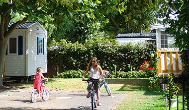 Enfants faisant du vélo dans une allée du parc du camping en Vendée Le Bois Tordu