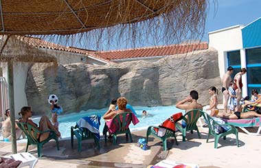 Famille de campeurs devant l'espace aquatique du camping Le Bois Tordu 85