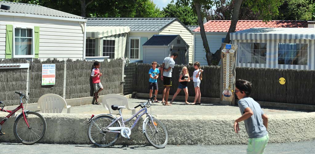 Kinder spielen Fahrrad und Pétanque auf dem Campingplatz in der Vendée le Bois Tordu